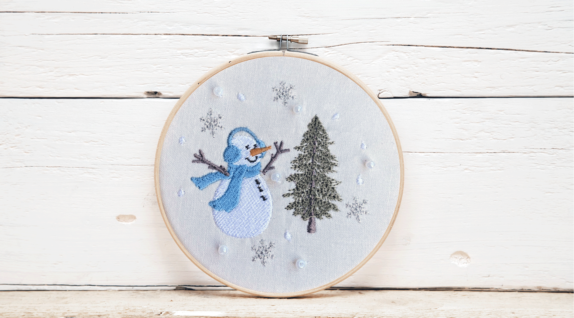 Cute snowman machine embroidered design with detailed stitching.