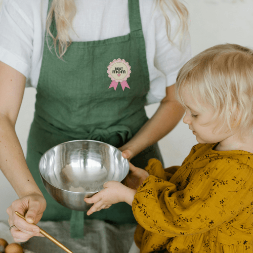 Mom cooking with child wearing an embroidered Mother's day apron.