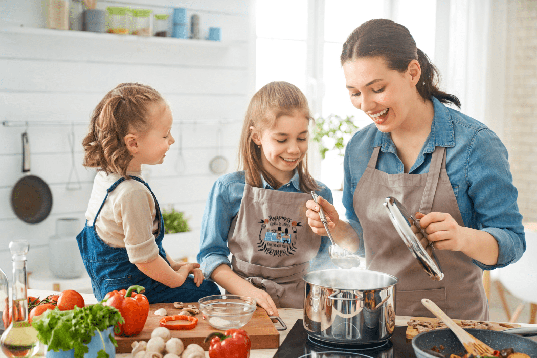 Mom and kids cooking in the kitchen, wearing embroidered aprons – showcasing family fun and custom embroidered designs.