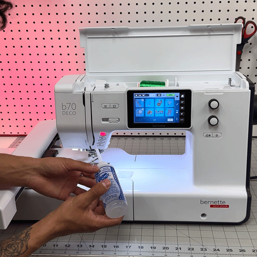 Embroiderer ensuring proper maintenance and oiling of a single needle embroidery machine.